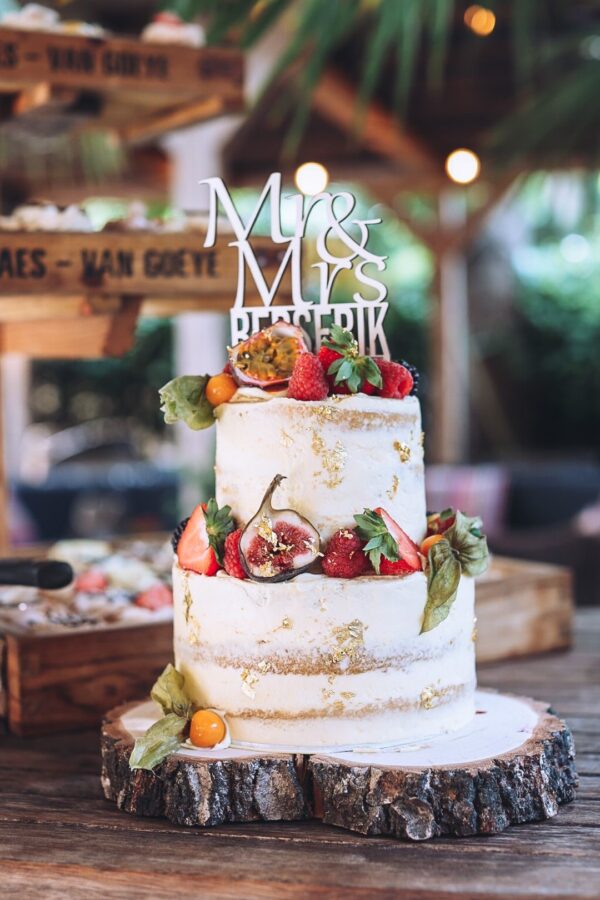 Naked cake met vers fruit, houten schijf en taarttopper